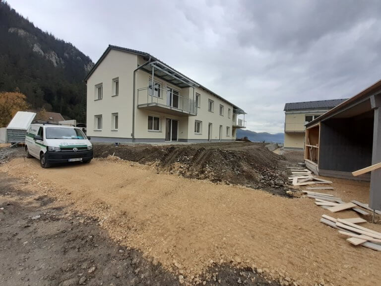 Neubau eines Mehrfamilienhauses mit Baustelle im Vordergrund.