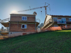 Wohnhäuser im Rohbau mit Richtbaum und Kran bei der Gleichenfeier der Siedlung Bartholomä im November 2024.