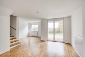 Helles Wohnzimmer einer modernen Wohnung in der Siedlung Bartholomä mit Blick auf die Terrasse
