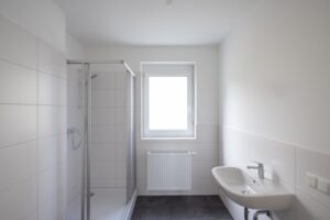Modernes Badezimmer mit Dusche und Fenster in der Siedlung Bartholomä