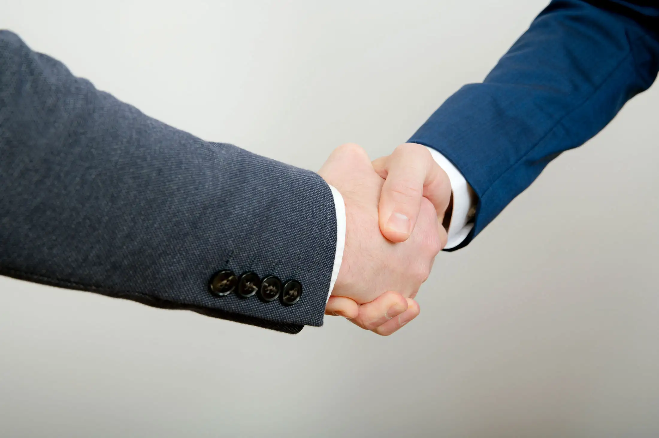 Händedruck in Businesskleidung – symbolische Partnerschaft im Bauwesen bei Hoppaus & Hasslinger