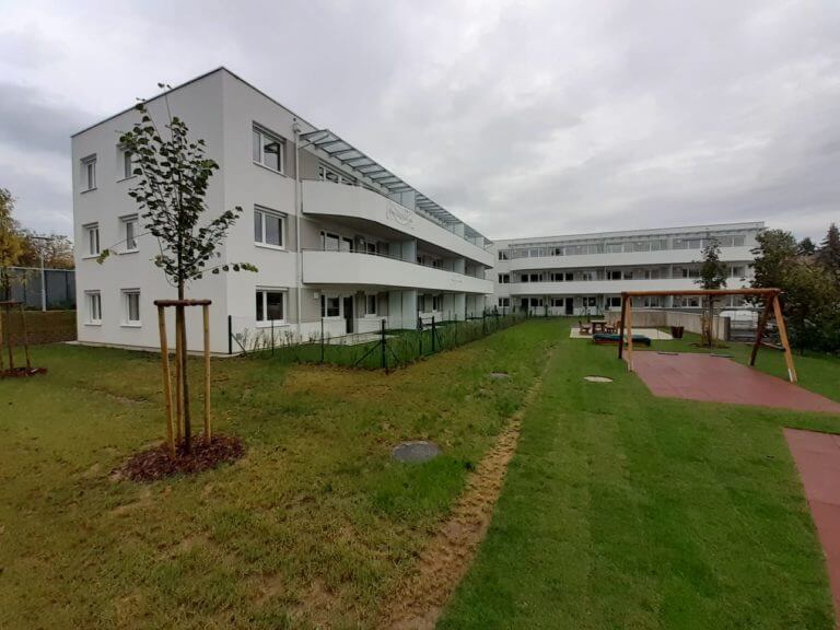 Neubau einer Wohnanlage mit Spielbereich und Grünfläche.