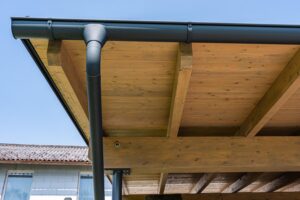 Holzverkleidetes Carportdach mit schwarzer Dachrinne