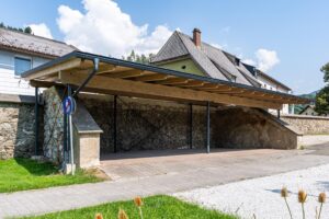 Carportkonstruktion mit Holzträgern, Stahlstützen und Ziegeldach