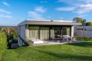 Gartenansicht auf modernes Wohnhaus mit Holzterrasse