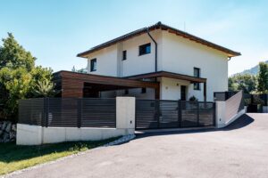 Wohnhaus umgeben von einer Kombination aus Metallzaun und starker Grenzmauer