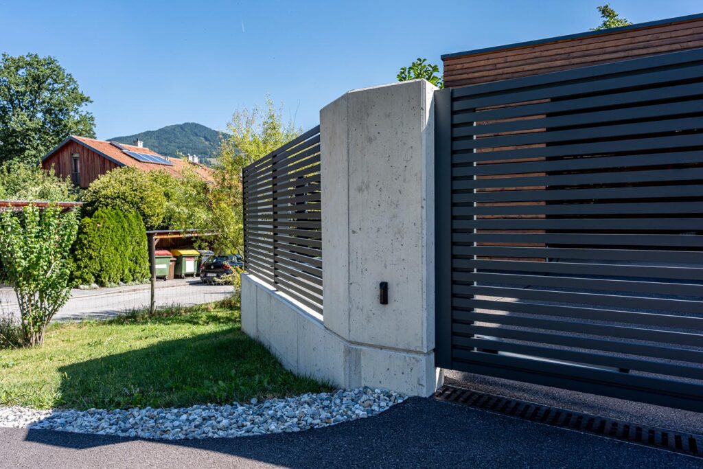 Eindrucksvoller Zaunpfeiler – gebogene Betonform trifft moderne Metallgestaltung